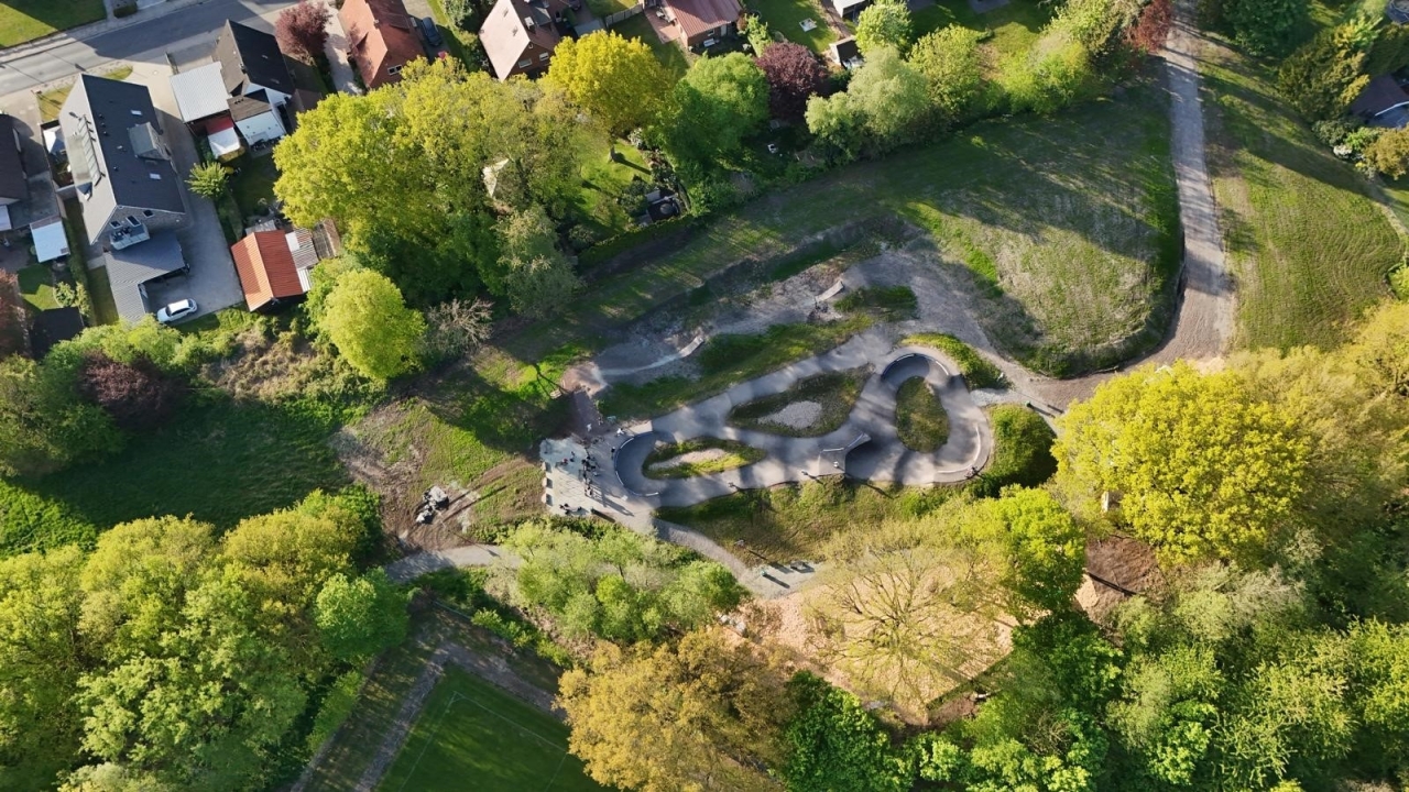 Bikepark Papenburg 30.05.2025 - Weiteres Foto aus der Vogelperspektive. Die Anlage grenzt auf einer Seite an einem Fußballplatz des beteiligten Sportvereins SC Blau-Weiß Papenburg und auf der anderen Seite an Wohnbebauung. 